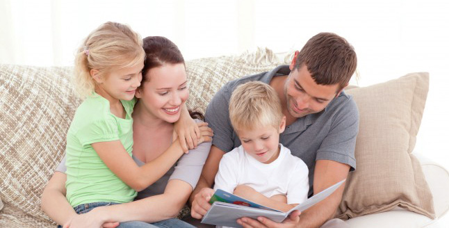 parents-et-enfants-en-train-de-lire-sur-le-divan